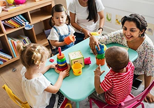 Educator guiding children during a table activity